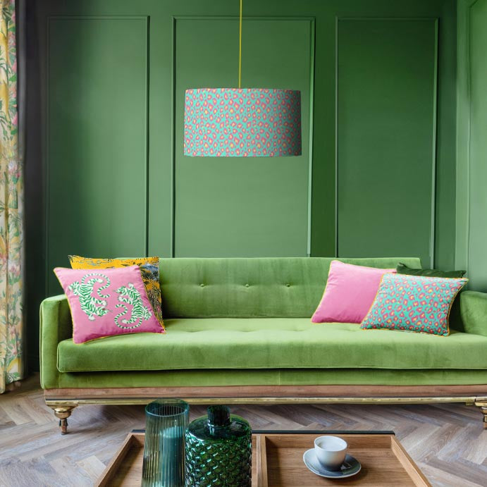 Fearless leopard lampshade and cushion in green living room with green sofa