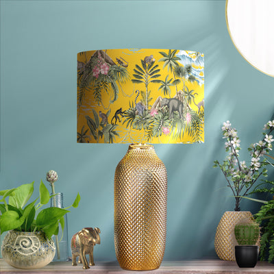 Mustard Yellow Lemur Island Lampshade & Gold Lining on a gold lamp base, pictured in liviing room setting