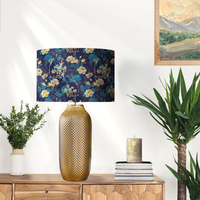 Navy Blue Gold Flower Lampshade with Mirror Gold Lining, on gold lamp base in white wall living room with painting and plants