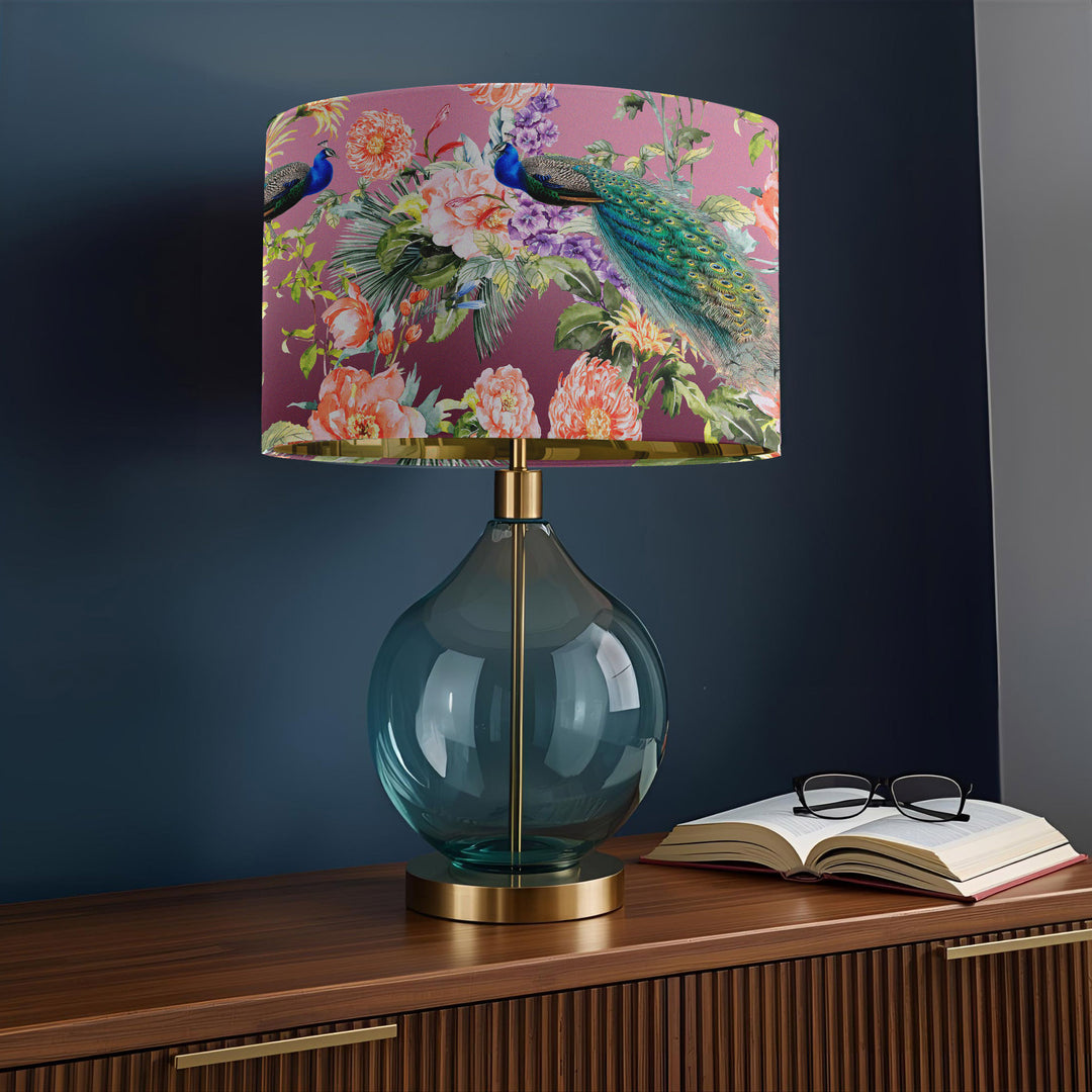 Peacock Paradise velvet lampshade on a glass and brass table lamp styled on a wooden sideboard in a modern home.